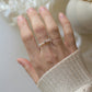 Glasperlenring mit Edelstahlperle gezeigt an einer Hand auf hellen Untergrund